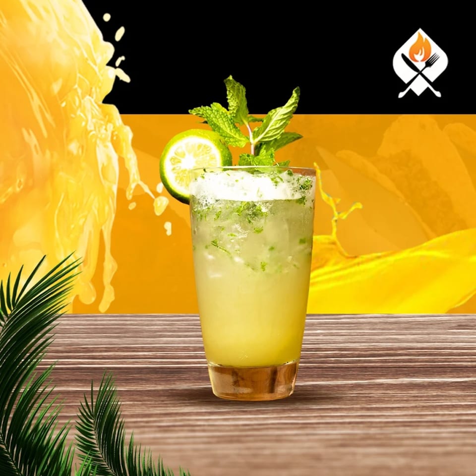Refreshing mojito with lime and mint on a wooden table, with a vibrant yellow background.